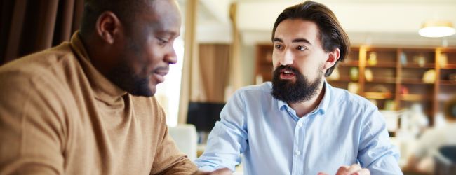 two men talking at table